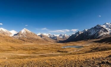 Panoramic view of Shimshal Pass at 4,735m, vast Pamir plateau surrounded by snow-capped Karakoram peaks, Pakistan