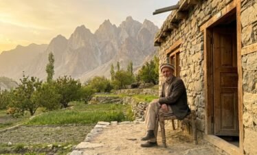 Traditional stone houses of Hushe village with terraced green fields and towering rocky Karakoram peaks, gateway to Nangma Valley Skardu Pakistan
