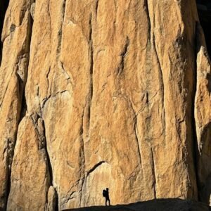 Towering vertical granite rock face in Nangma Valley Skardu Pakistan, known as the Yosemite of the Karakoram, trekker at base for scale