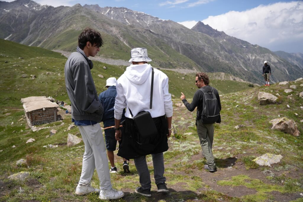 North Nomads guide leading a group of trekkers on the mountain trail above Fairy Meadows, northern Pakistan