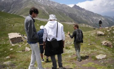 North Nomads guide leading a group of trekkers on the mountain trail above Fairy Meadows, northern Pakistan