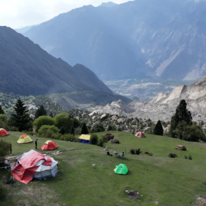 Aerial drone view of colourful expedition tents on the hillside above a dramatic Karakoram valley, Rakaposhi Base Camp trek Pakistan