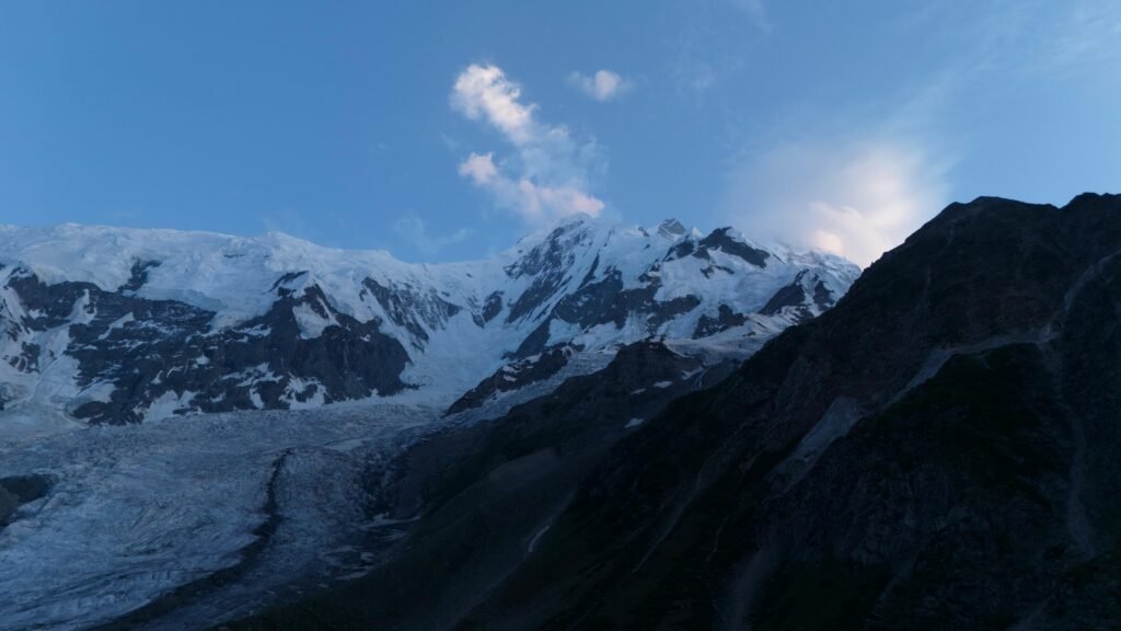 Rakaposhi mountain and glacier at blue hour dusk, dramatic evening light on snow-capped Karakoram peak, northern Pakistan