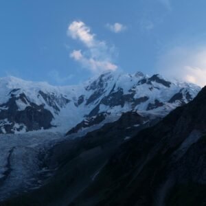 Rakaposhi mountain and glacier at blue hour dusk, dramatic evening light on snow-capped Karakoram peak, northern Pakistan