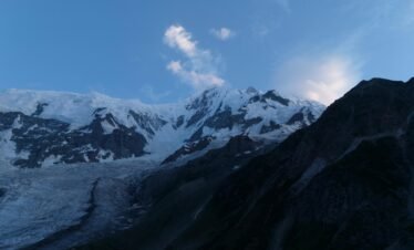 Rakaposhi mountain and glacier at blue hour dusk, dramatic evening light on snow-capped Karakoram peak, northern Pakistan
