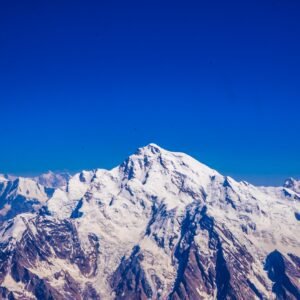 Aerial view of Rakaposhi summit at 7,788m rising above the Karakoram range against a deep blue sky, northern Pakistan