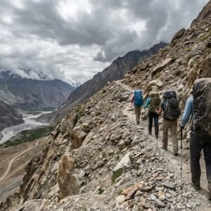 Trekkers with backpacks ascending the rocky trail toward Shimshal Pass on a trekking tour in northern Pakistan