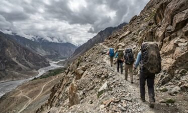Trekkers with backpacks ascending the rocky trail toward Shimshal Pass on a trekking tour in northern Pakistan
