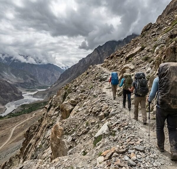 Trekkers with backpacks ascending the rocky trail toward Shimshal Pass on a trekking tour in northern Pakistan