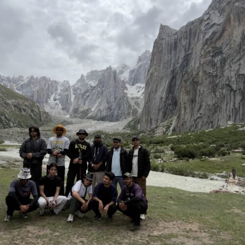 Trekking Group at Nangma Glacier, Kanday Village, Skardu, Pakistan Description: A trekking group poses at the base of Nangma Glacier near Kanday village, Skardu district, Gilgit-Baltistan, with the jagged granite spires of the Nangma Valley cirque and grazing yaks in the background.