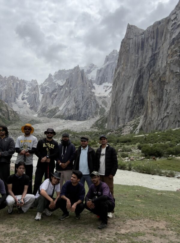 Trekking Group at Nangma Glacier, Kanday Village, Skardu, Pakistan Description: A trekking group poses at the base of Nangma Glacier near Kanday village, Skardu district, Gilgit-Baltistan, with the jagged granite spires of the Nangma Valley cirque and grazing yaks in the background.